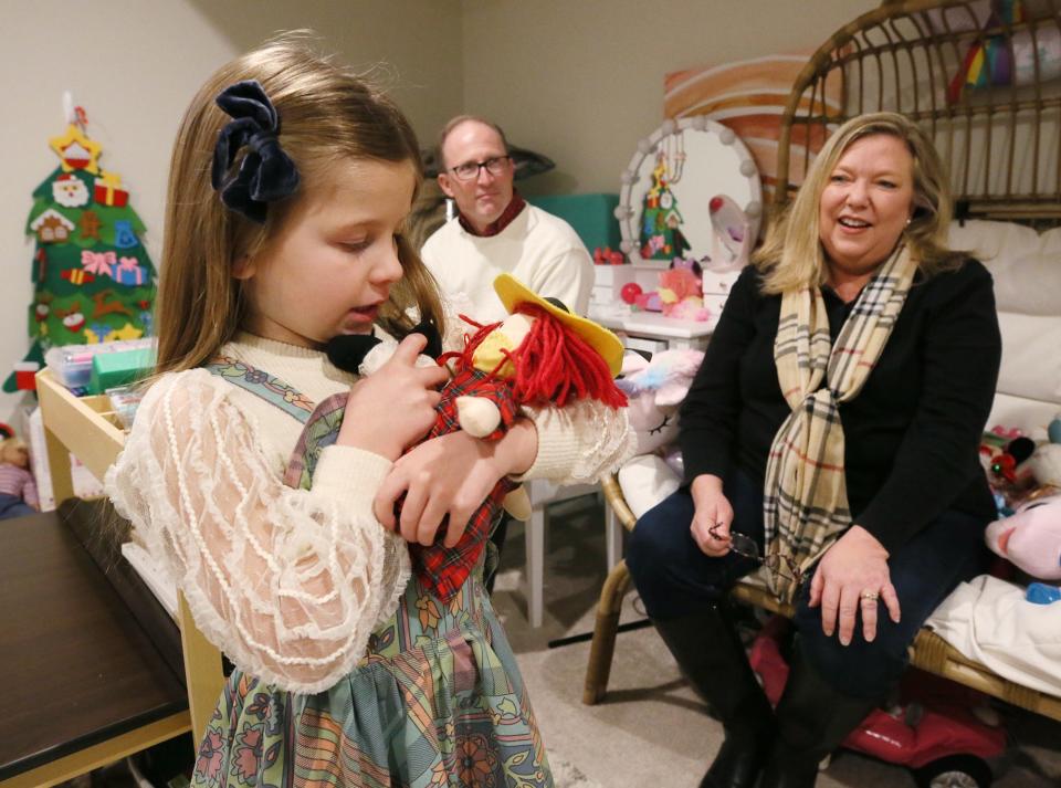 LJ Horvath, 5, plays with a Madeline doll, a gift from surrogate grandparents Rich and Lara Wilson.