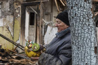 Inna, 71, holds food items found as she stands outside of her house which was destroyed by a Russian drone attack in a residential neighbourhood, in Zaporizhzhia, Ukraine, on Thursday, March 28, 2024. (AP Photo/Andriy Andriyenko)