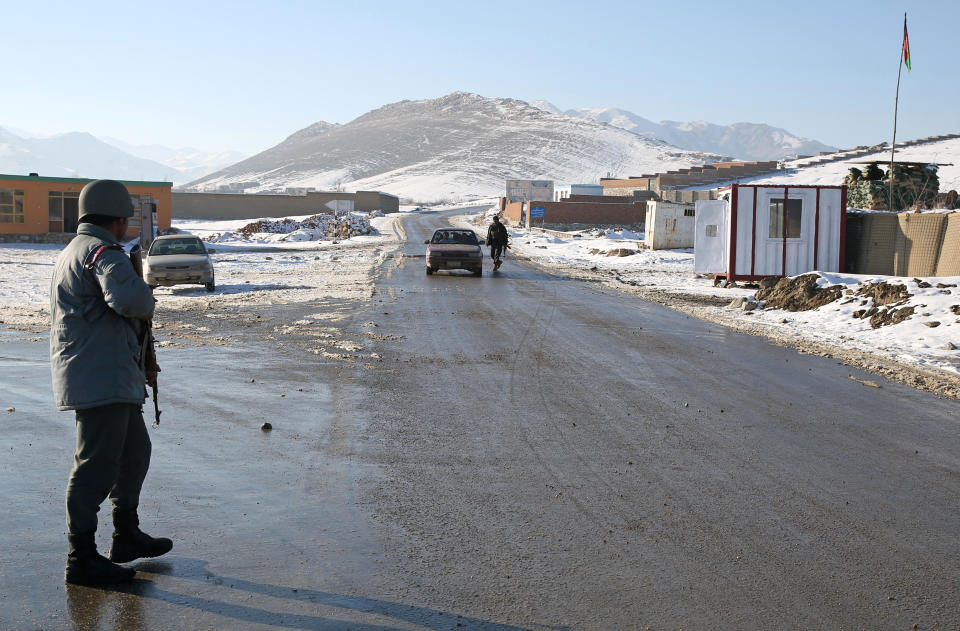 In this Thursday, Jan. 9, 2014 photo, an Afghan policemen stand guard at a check post in Kabul-Bamiyan road, on the outskirts of Maidan Shahr, capital of Wardak province Afghanistan, Thursday, Jan. 9, 2014. Locals call it "Death Road." The 30 kilometer (18 mile) stretch of road heading west from here has seen so many beheadings, kidnappings and other Taliban attacks in recent years that it's become a virtual no man's land, cutting off the Hazara minority from their homeland in Afghanistan's rugged mountainous center. (AP Photo/Massoud Hossaini)
