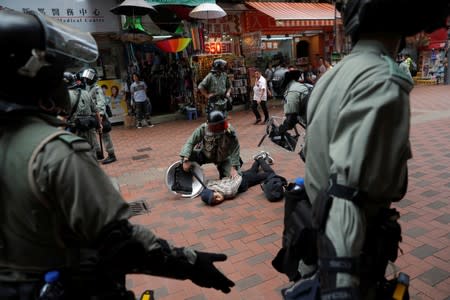 Riot police officers detain an anti-government protester during a gathering in Tsuen Wan, near the site where police shot a protester with live ammunition on China's National Day in Hong Kong