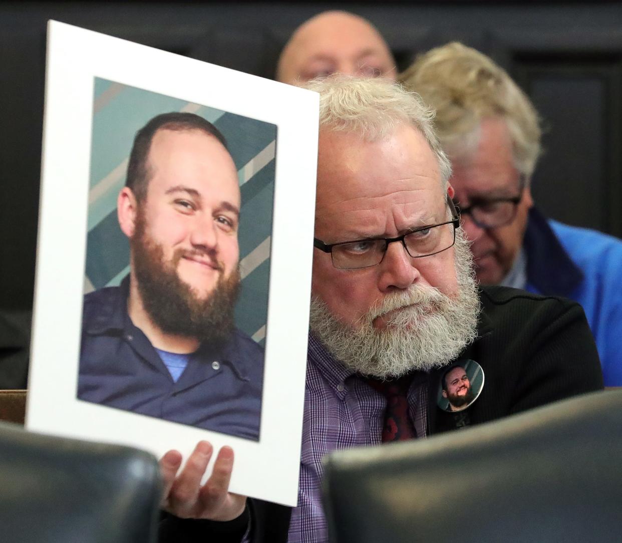 George Jensen Sr. holds up a portrait of his son George "Geo" Jensen as he sits in on the sentencing of Dacarrei Kinard for the drive-by shooting death of his son last May in Judge Kathryn Michael's courtroom at the Summit County Courthouse, Friday, April 12, 2024, in Akron, Ohio. His sonÕs killer was sentenced to 15-17 and a half years in prison.