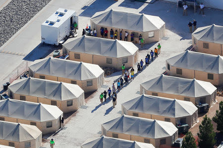 FILE PHOTO: Immigrant children now housed in a tent encampment under the new "zero tolerance" policy by the Trump administration are shown walking in single file at the facility near the Mexican border in Tornillo, Texas, U.S. June 19, 2018. REUTERS/Mike Blake