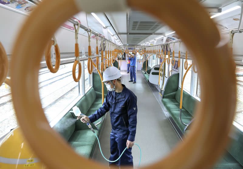 A worker sprays an antiviral liquid inside a train amid the coronavirus disease (COVID-19) outbreak in Osaka, Japan