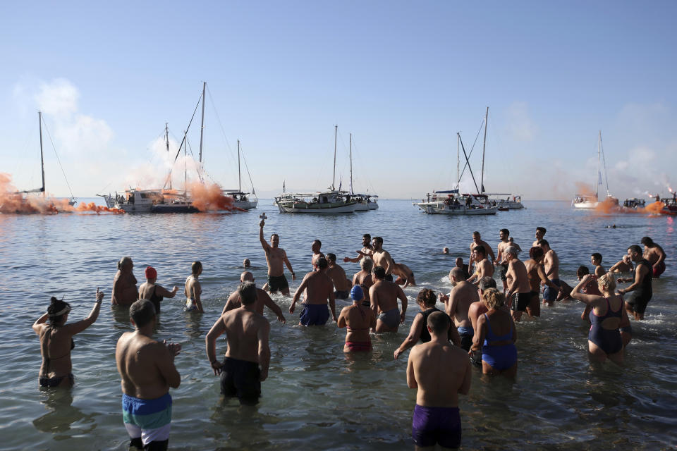 <p>Angelos Filoxenidis, center, raises a cross retrieved from the sea during a water blessing ceremony marking the Epiphany celebrations in the Paleo Faliro suburb, southern Athens, Greece, Saturday, Jan. 6, 2018. (Photo: Thanassis Stavrakis/AP) </p>