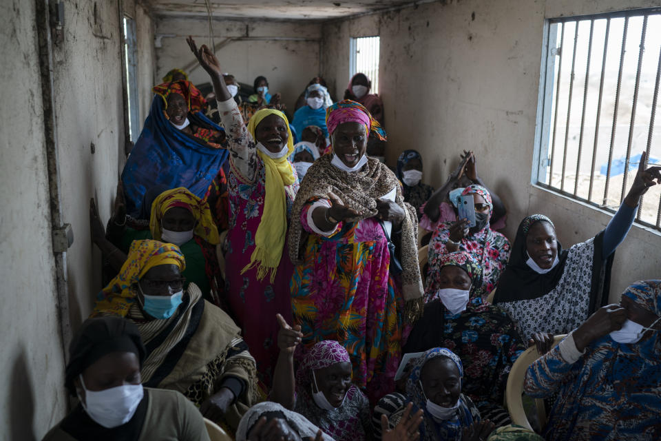 Siny Gueye, center left, is joined by other women fish processors to sing a blessing and thankful song at Bargny beach, some 35 kilometers (22 miles) east of Dakar, Senegal, Thursday April 1, 2021. (AP Photo/Leo Correa)