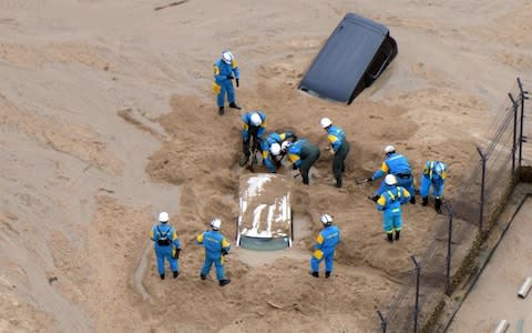 Rescue workers dig to search missing people in Hiroshima - Credit: Getty