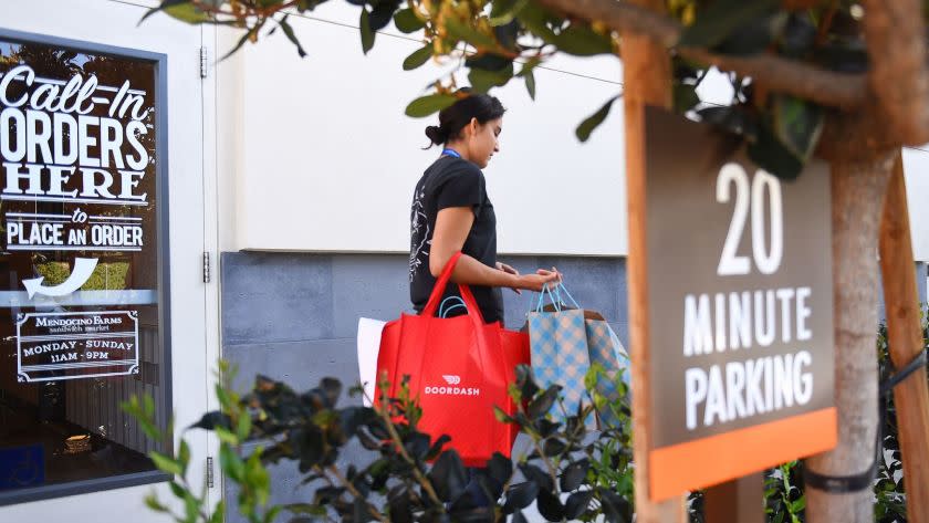 DoorDash deliverer Ricky Sierra picks up an order at Mendocino Farms in El Segundo.