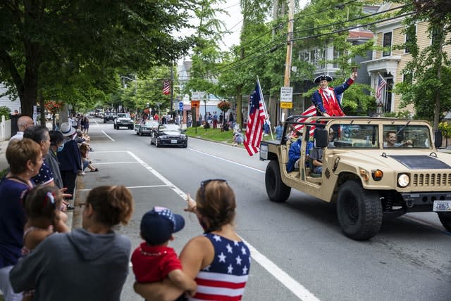 Spectators watch as a Fourth of July parade passes in Bristol, Rhode Island