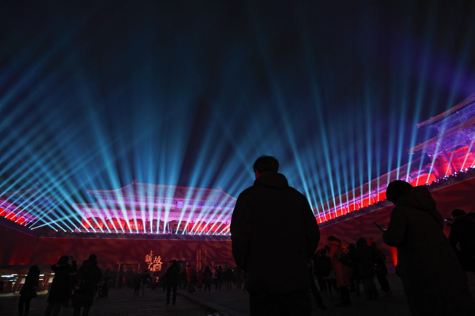 In this Tuesday, Feb. 19, 2019, file photo, visitors watch the Wumen Gate wall of the Forbidden City illuminated with lights for the Lantern Festival in Beijing. China lit up the Forbidden City on Tuesday night, marking the end of 15 days of lunar new year celebrations. It was not a Lantern Festival the last emperor, who abdicated in 1912, would have recognized. There were lanterns, but those lucky enough to snag tickets saw a laser light show and historic buildings bathed in colorful lights. Others watched from outside the vast walled compound in Beijing, from where Ming and Qing dynasty emperors ruled for five centuries. (AP Photo/Andy Wong, File)