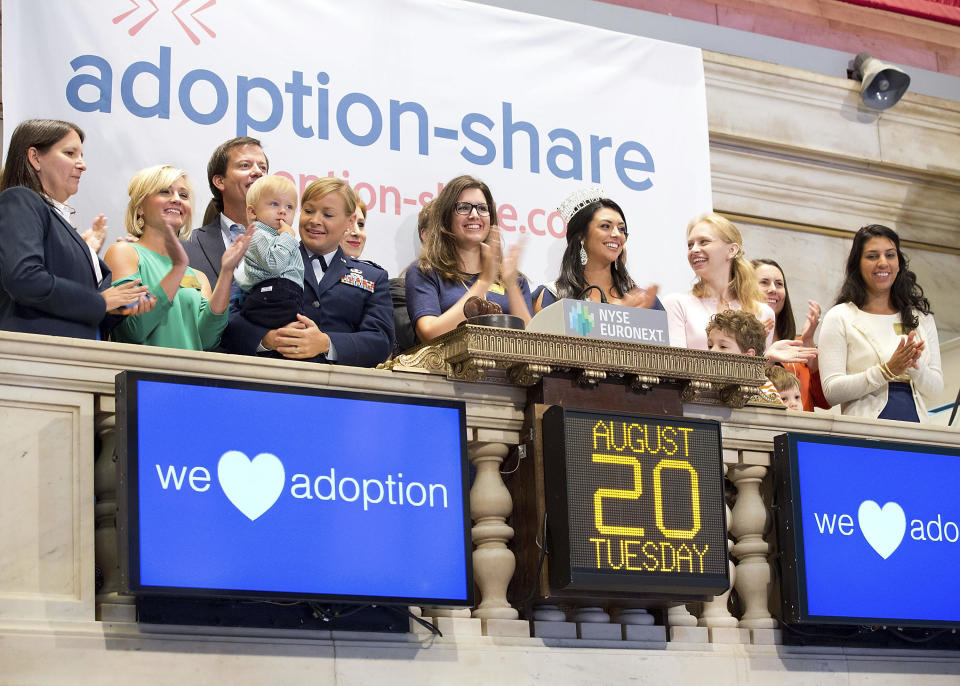 In this photo provided by the New York Stock Exchange, Adoption-Share founder and CEO Thea Ramirez, center, Miss Utah USA 2013 Marissa Powell, center right, and fellow adoption supporters ring the opening bell at the New York Stock Exchange in New York on Aug. 20, 2013. An Associated Press investigation found that Adoption-Share’s tool – among the few adoption algorithms on the market in 2023 – has produced limited results in the states where it has been used, according to the organization’s self-reported data that AP obtained through public records requests from state and local agencies. (NYSE via AP)