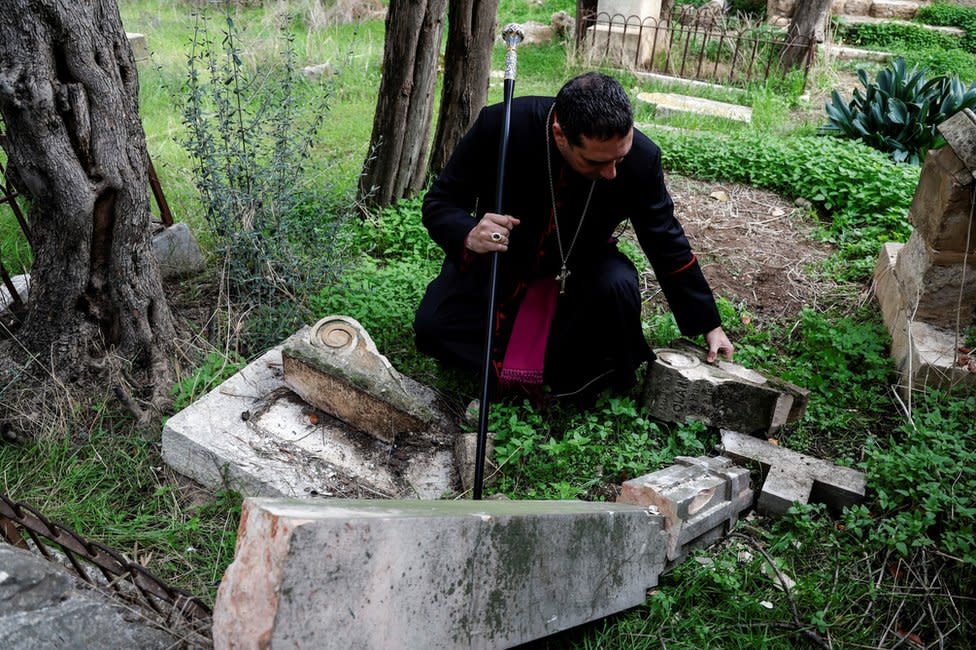 El arzobispo Hosam Naoum inspecciona una tumba profanada en el cementerio protestante del Monte Sión en Jerusalén (4 de enero de 2023).