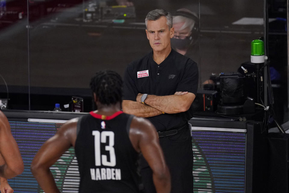 Oklahoma City Thunder head coach Billy Donovan, rear, looks onto the court as Houston Rockets' James Harden (13) walks by during the second half of an NBA first-round playoff basketball game in Lake Buena Vista, Fla., Wednesday, Sept. 2, 2020. (AP Photo/Mark J. Terrill)