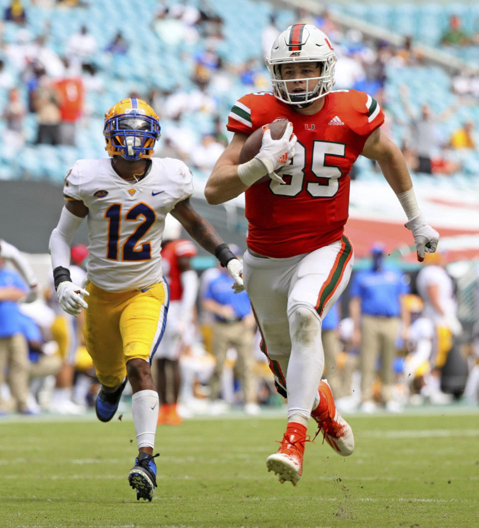 Miami tight end Will Mallory (85) runs for a touchdown after a reception as Pitt safety Paris Ford (12) pursues in the second half of an NCAA college football game in Miami Gardens, Fla., Saturday, Oct. 17, 2020. (Al Diaz/Miami Herald via AP)