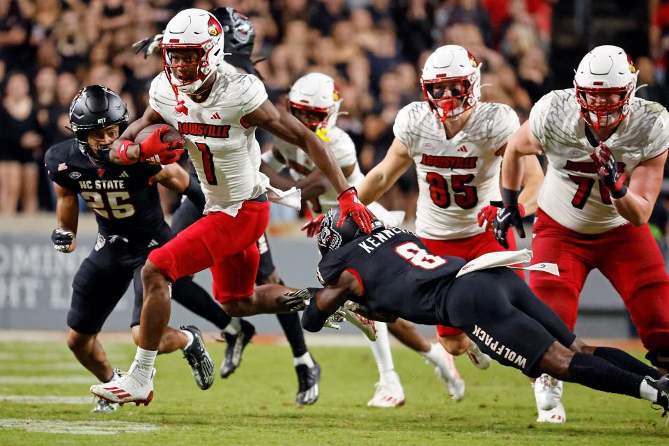 Louisville's Jamari Thrash (1) slips the tackle of North Carolina State's Robert Kennedy (8) during the second half of an NCAA college football game in Raleigh, N.C., Friday, Sept. 29, 2023. (AP Photo/Karl B DeBlaker)