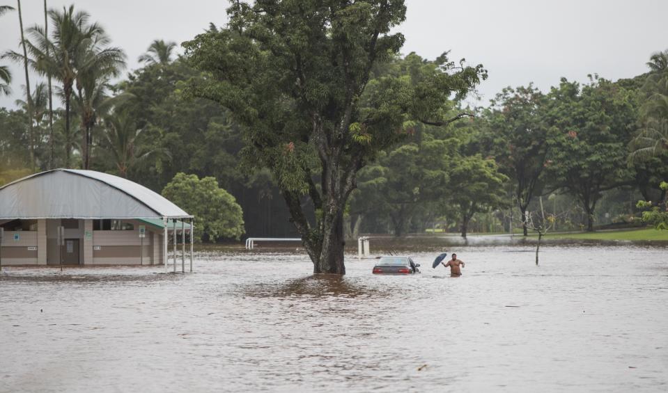 <p>A owner of a stranded car attempts to retrieve items from it as an excessive amount of rain from Hurricane Lane causes flooding, submerging the Bayfront soccer fields, around Hilo, Hawaii, Aug. 23, 2018. (Photo: Bruce Omori/EPA-EFE/REX/Shutterstock) </p>