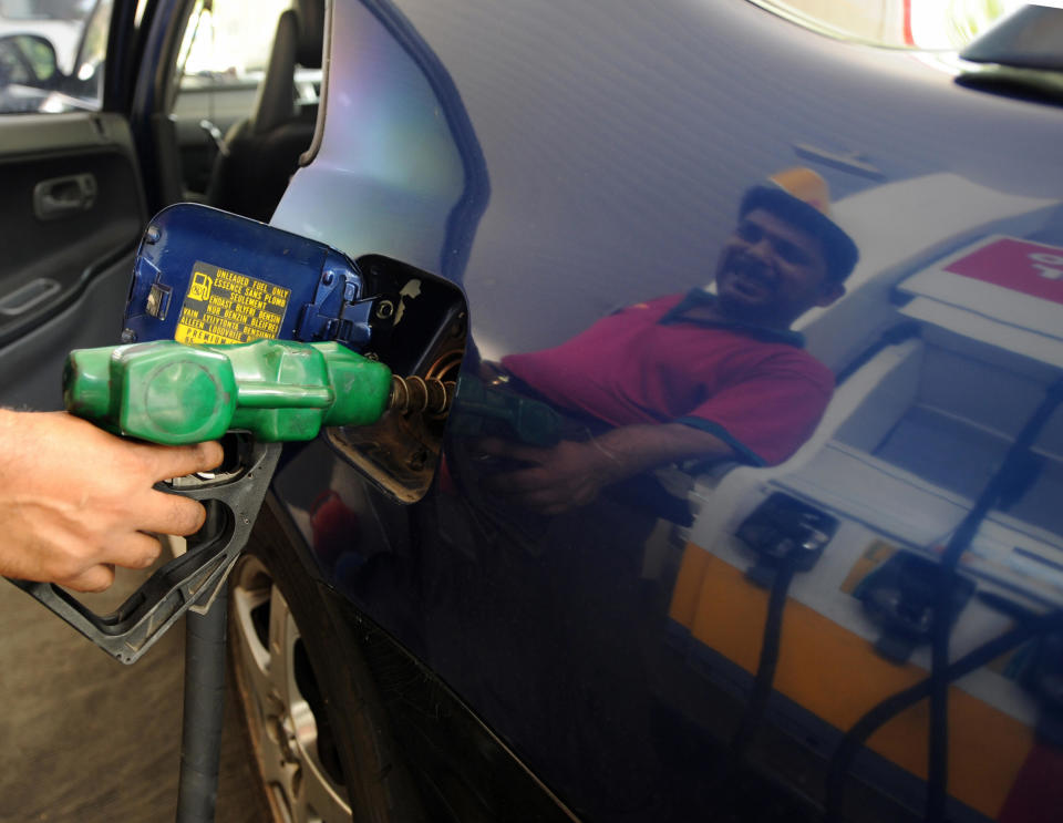 A pump attendant fills up a vehicle with fuel at a petrol kiosk in Singapore. (PHOTO: Roslan Rahman/AFP via Getty Images)