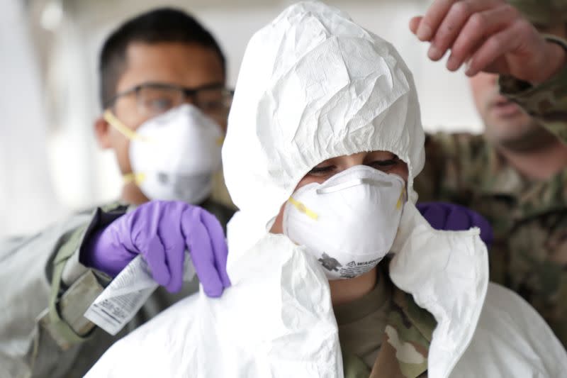 Rhode Island National Guard Sergeant Cora Brown is fitted with protective gear during training to administer coronavirus disease tests