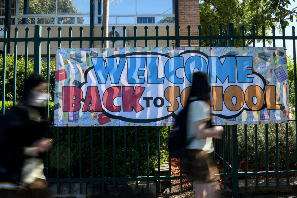 A 'Welcome Back to School' banner hangs on the fence as students in years 2-11 return to school at Fairvale High School in Sydney in October. Source: AAP