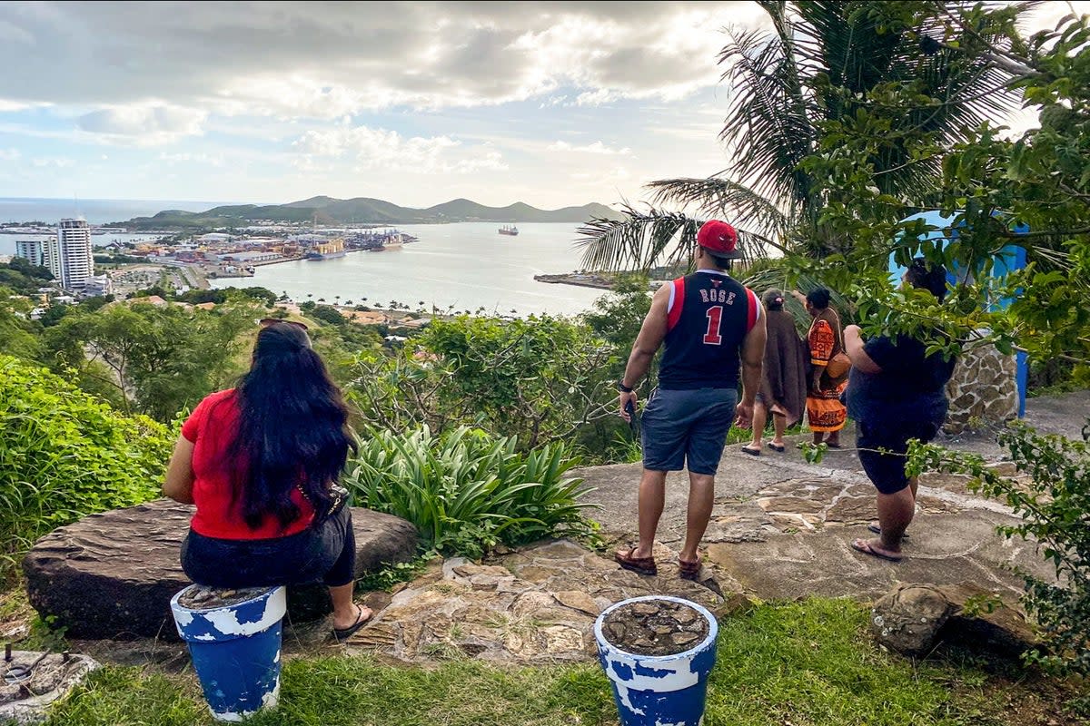 People look out toward the seafront from the Vierge du Pacifique in Noumea following earthquake reports (AFP via Getty Images)