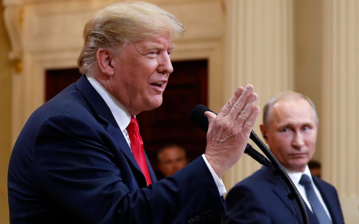 Donald Trump speaks with Russian President Vladimir Putin during a press conference after their meeting at the Presidential Palace in Helsinki - AP