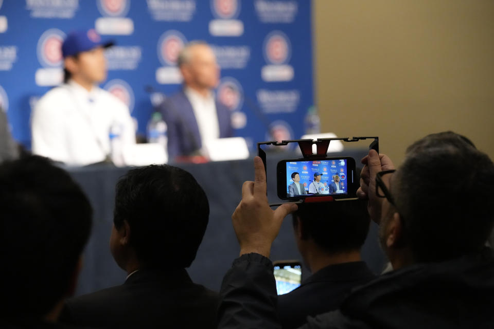 A person takes a video as new Chicago Cubs pitcher Shōta Imanaga speaks during news conference Friday, Jan. 12, 2024, in Chicago. The Japanese left-hander is expected to step right into the baseball team's rotation as it tries to return to the playoffs for the first time since 2020. (AP Photo/Nam Y. Huh)