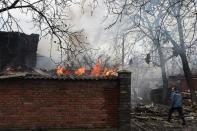 A firefighter passes a burning house after shelling destroyed several homes in the eastern Ukrainian city of Donetsk, on February 3, 2015