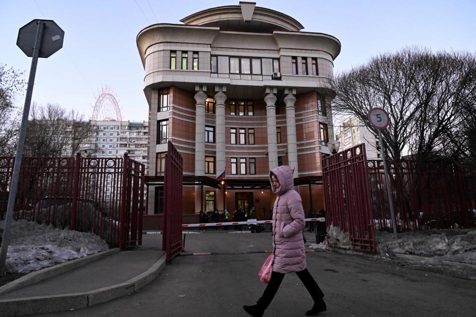 A woman walks past the Ostankinsky District Court, where a hearing of the case of Marina Ovsyannikova - the editor at the state broadcaster Channel One who protested against Russian military action in Ukraine during the evening news broadcast at the station late Monday - is held, in Moscow on March 15, 2022. A Russian TV editor who burst onto the set of a popular evening news show to voice dissent over Moscow's military operation in Ukraine said in court on March 15 she was not guilty of protesting illegally. 