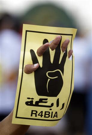 A member of the Muslim Brotherhood and supporter of ousted Egyptian President Mursi holds up a sign showing the "Rabaa" or "four" gesture, in reference to the police clearing of the Rabaa al-Adawiya protest camp on August 14, during a protest named "People Protect the Revolution" as they march towards the "Qasr al-Quba" presidential palace in Cairo, September 6, 2013. REUTERS/Amr Abdallah Dalsh