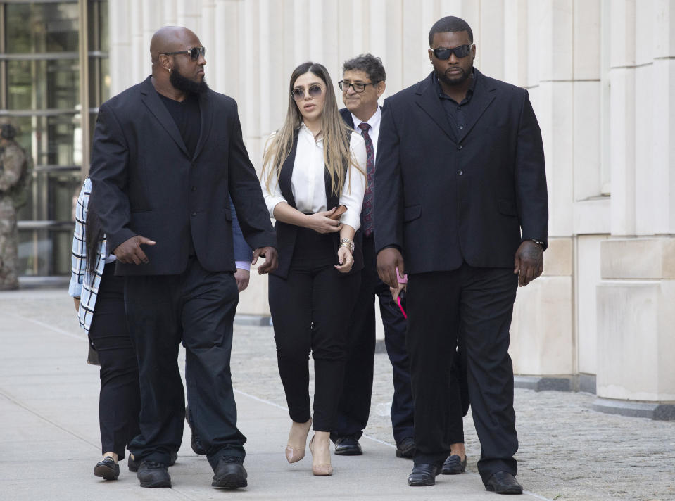 FILE- In this July 17, 2019 file photo, New York City police officer Ishmael Bailey, right, moonlights as a bodyguard for Emma Coronel Aispuro, wife of Mexican drug lord Joaquin "El Chapo" Guzman, as they leave Brooklyn federal court in New York, following Guzman's sentencing. Despite her status as the wife of the world’s most notorious drug boss, Coronel Aispuro lived mostly in obscurity -- until her husband went to prison for life. (AP Photo/Mark Lennihan, File)