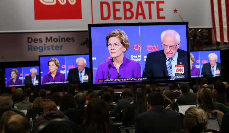 FILE PHOTO: Democratic 2020 U.S. presidential candidates Senator Elizabeth Warren and Senator Bernie Sanders are seen on television monitors in the press room at the seventh Democratic 2020 presidential debate at Drake University in Des Moines