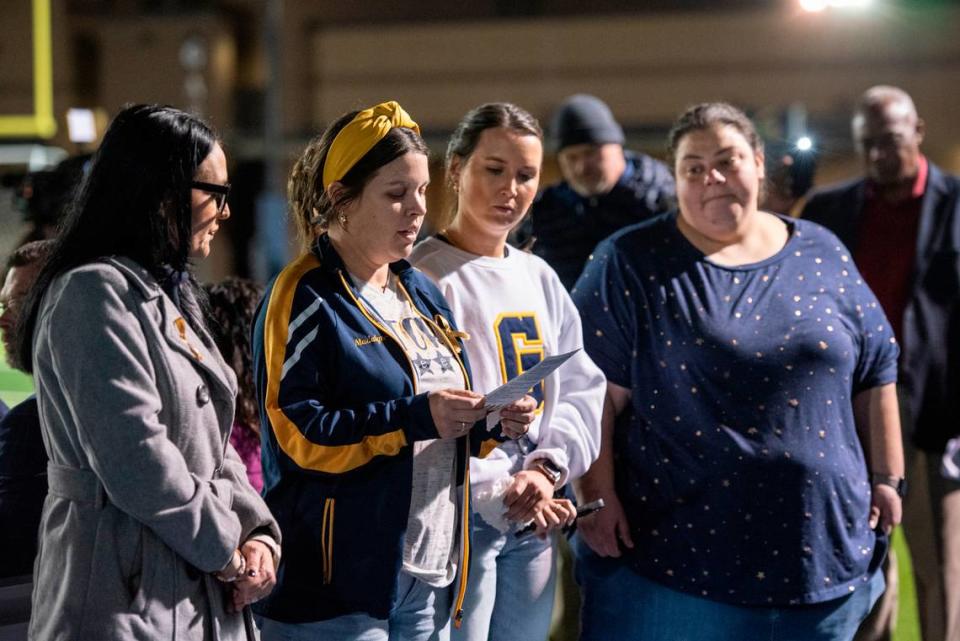 Rev. MJ Kirby of First United Methodist Gautier and members of the Gautier cheerleading coaching staff lead a litany of hope during a candlelight vigil in honor and memory of three Gautier High School graduates at Gautier High School in Gautier on Thursday, Dec. 7, 2023. Se’Dhari Saniya Watson-Person, Kyla “Muffin” Watkins, and Tatyanna Richmond were involved in a fatal crash on Tuesday, leading to the deaths of Watson-Person and Watkins. Richmond remains hospitalized.