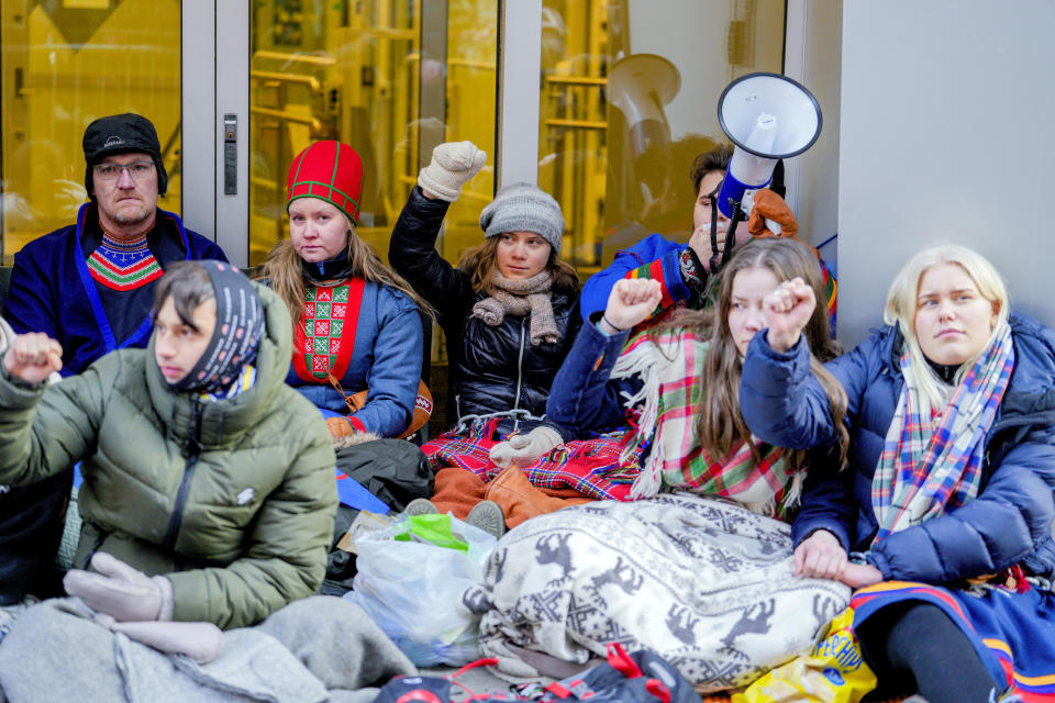 Swedish activist Greta Thunberg, centre, sits with other activists in front of the Ministry of Trade and Fisheries as they protest against a wind farm they say hinders the rights of the Sami Indigenous people to raise reindeer in Arctic Norway, in Oslo, Thursday, March 2, 2023. (Javad Parsa/NTB Scanpix via AP)