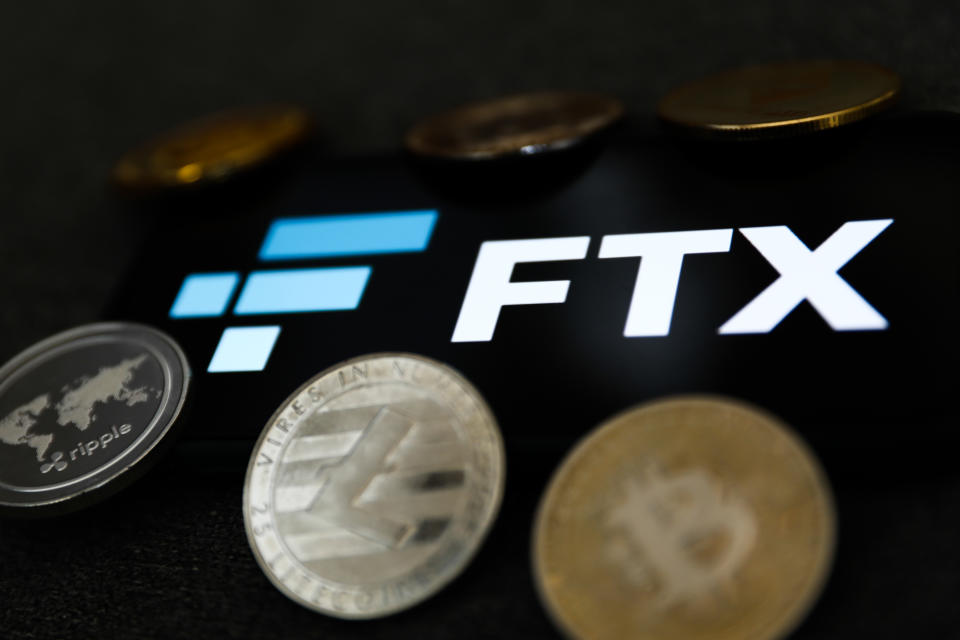 FTX logo displayed on a phone screen and representation of cryptocurrency are seen in this illustration photo taken in Krakow, Poland on February 16, 2022. (Photo illustration by Jakub Porzycki/NurPhoto via Getty Images)