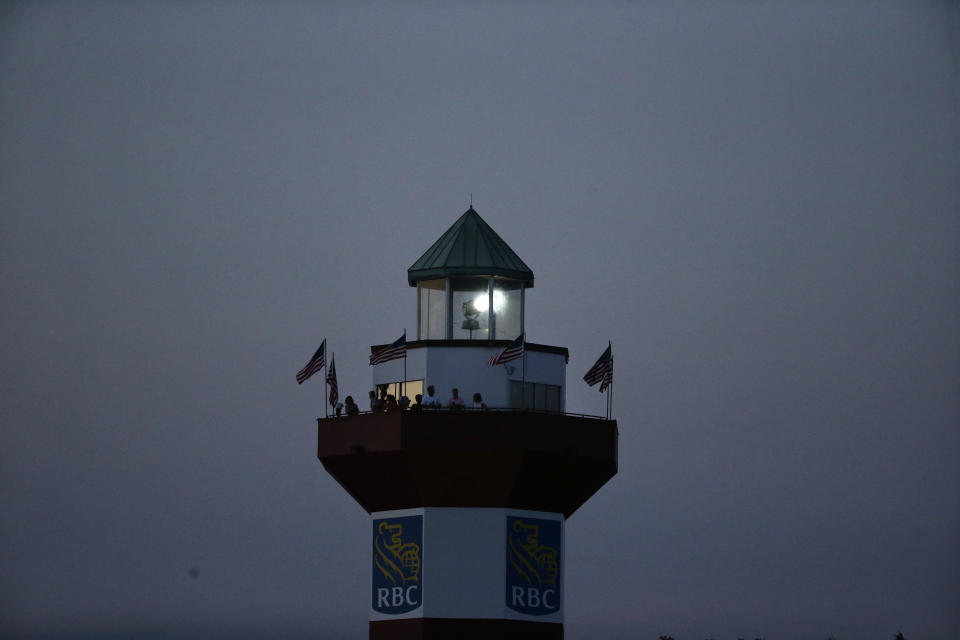 Fans watch from a lighthouse as night falls, as Webb Simpson wins on the 18th green, on a course with no fans due to the COVID-19 pandemic, during the final round of the RBC Heritage golf tournament, Sunday, June 21, 2020, in Hilton Head Island, S.C. (AP Photo/Gerry Broome)