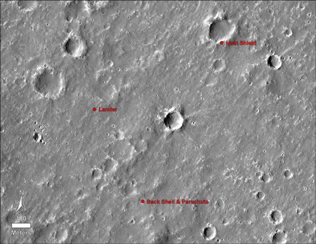 This image of the Martian surface was taken by the HiRISE camera on May 30, 2014. Annotations have been added to show where NASA’s InSight lander, its heat shield and its parachute ended up on Nov. 26, 2018. (NASA / JPL-Caltech / University of Arizona Photo)