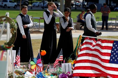 Youths in traditional clothing look at a makeshift memorial for the Pulse nightclub mass shooting victims last week in Orlando, Florida, U.S., June 21, 2016. REUTERS/Carlo Allegri