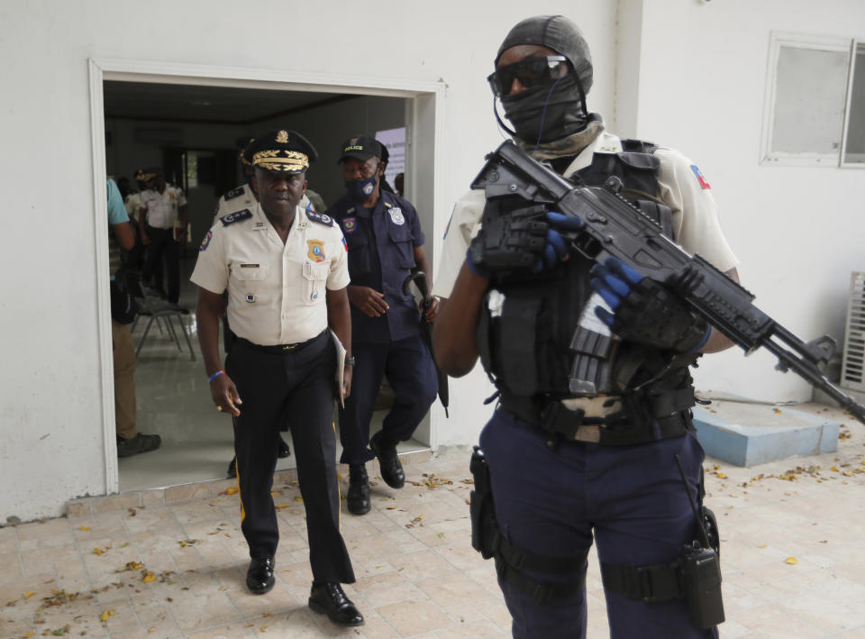 Leon Charles, left, Director General of Haiti's Police leaves a room after a news conference at police headquarters in Port-au-Prince, Wednesday, July 14, 2021. Charles gave an updated on the investigation of the July 7 assassination of President Jovenel Moise. (AP Photo/Fernando Llano)