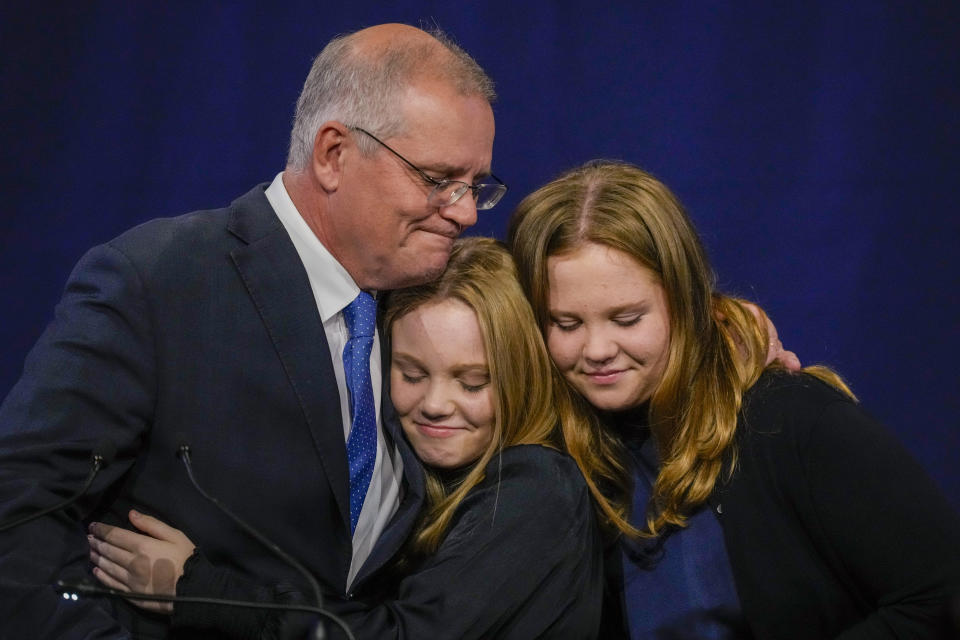 Australian Prime Minister Scott Morrison hugs his daughters Lily and Abbey at a Liberal Party function in Sydney, Australia, Saturday, May 21, 2022. Morrison has conceded defeat and has confirmed that he would hand over the leadership of the Liberal Party following his party's loss to Labor in today's federal election. (AP Photo/Mark Baker)