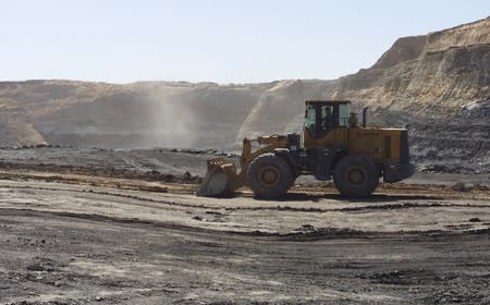 A mine worker drives a shovel truck across an open-cast coal mine located in the Ordos mining district