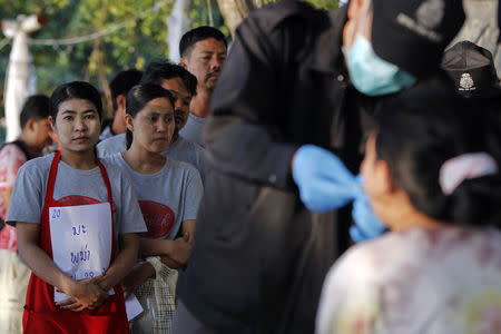 People wait in line as policemen collect data from those who work near the spot where bodies of two killed British tourists were found, on the island of Koh Tao September 19, 2014. REUTERS/Chaiwat Subprasom