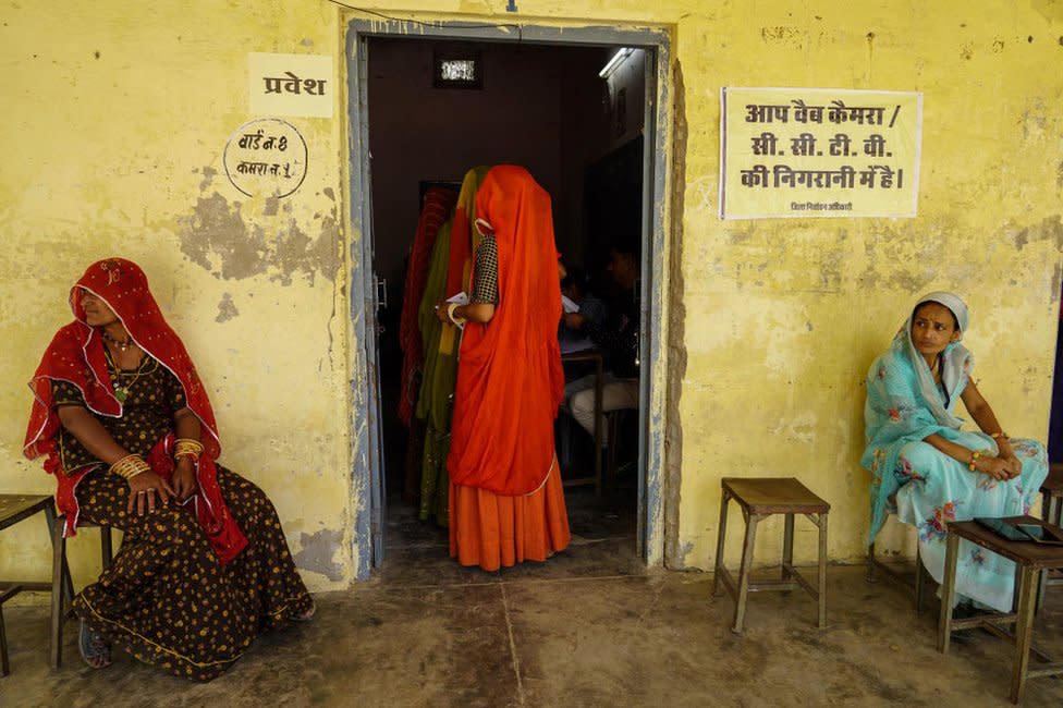 Women queue up to cast their ballot at a polling station in the first phase of voting for the India's general elections in Parbatsar in Rajasthan, on April 19, 2024. (