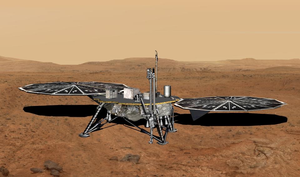 a squat lander with four legs and two large solar panels on the surface of a reddish-orange desert planet