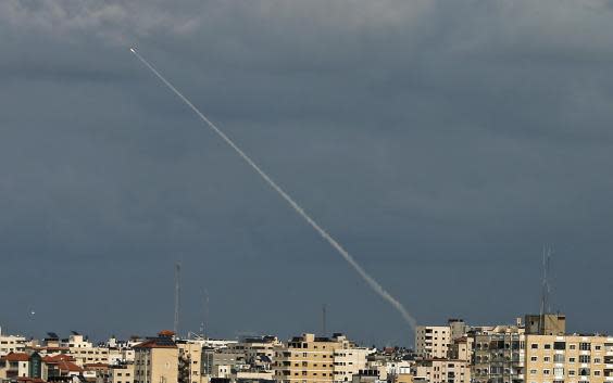 Smoke trails from a rocket fired by Palestinian militants over the Gaza Strip (Photo by MAHMUD HAMS/AFP via Getty Images)
