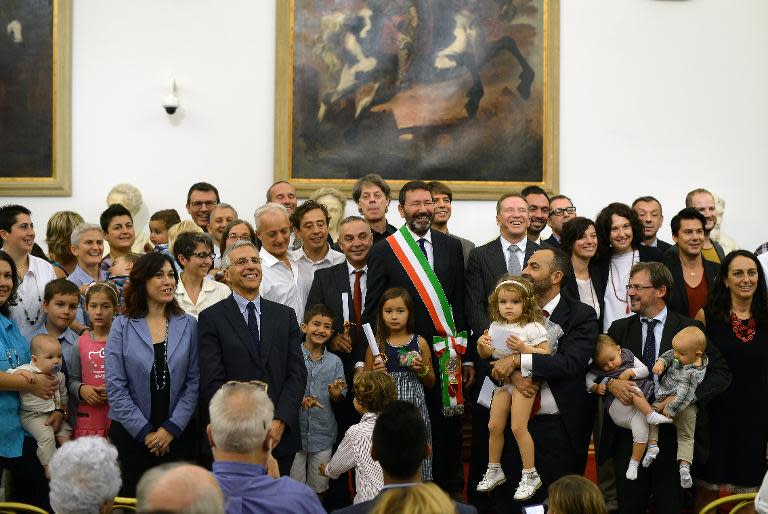 Rome's mayor, Ignazio Marino (C), poses with gay couples and their families after he registered 16 gay marriages on October 18, 2014 in Rome