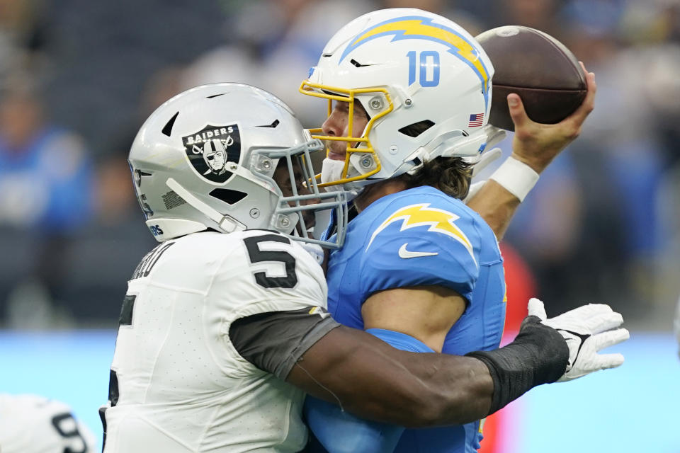 Los Angeles Chargers quarterback Justin Herbert (10) throws under pressure from Las Vegas Raiders linebacker Divine Deablo during the first half of an NFL football game Sunday, Oct. 1, 2023, in Inglewood, Calif. (AP Photo/Ryan Sun)