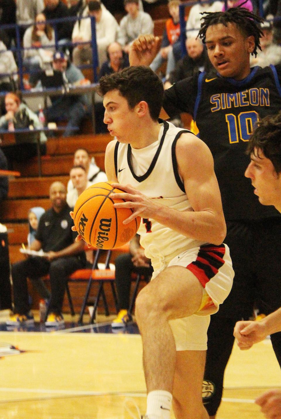 Sam Driscoll of Benet Academy hauls down a rebound against Wesley Rubin of Simeon. Rubin's Wolverines edged Benet for the title 52-49 Friday.