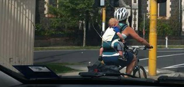 Cyclist rides with baby strapped to her back. Photo: Herald Sun