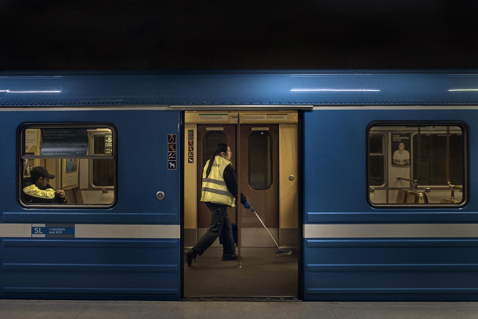 A worker cleans the subway before its departure in Akalla, Rinkeby-Kista borough, Stockholm, Sweden, Tuesday, April 28, 2020. The coronavirus has taken a disproportionate toll among Sweden's immigrants. Many in these communities are more likely to live in crowded households and are unable to work remotely. There also are concerns the message has not reached everyone in immigrant neighborhoods. (AP Photo/Andres Kudacki)