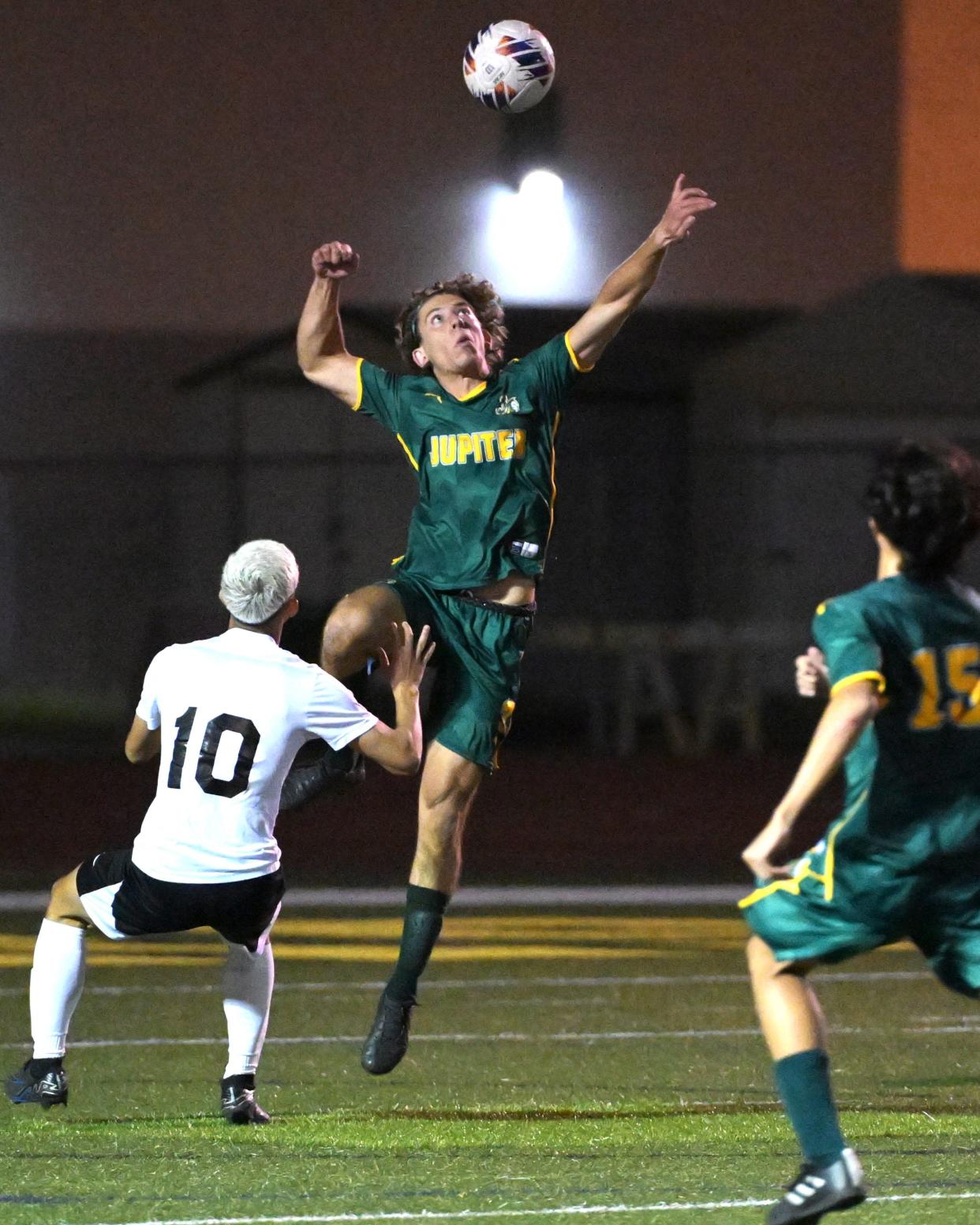 Jupiter's Noah Briant rises highest to head the ball, claiming possession for the Warriors during a regional quarterfinals match against Olympic Heights on Feb. 13, 2024.