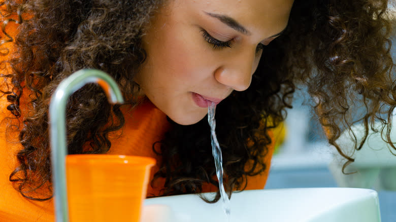 Woman spitting into sink